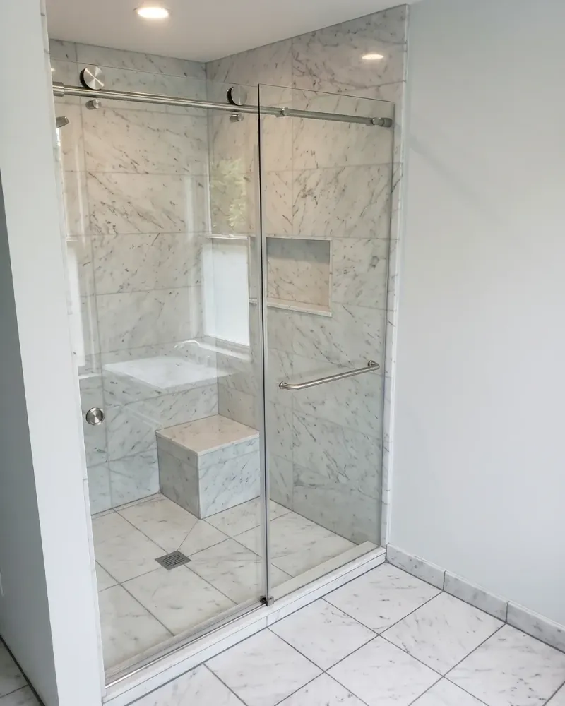 DIY sliding shower door project showing a finished glass enclosure in a tiled bathroom