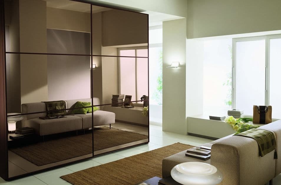 Modern living room featuring custom glass wall mirrors with a sleek beveled glass edge