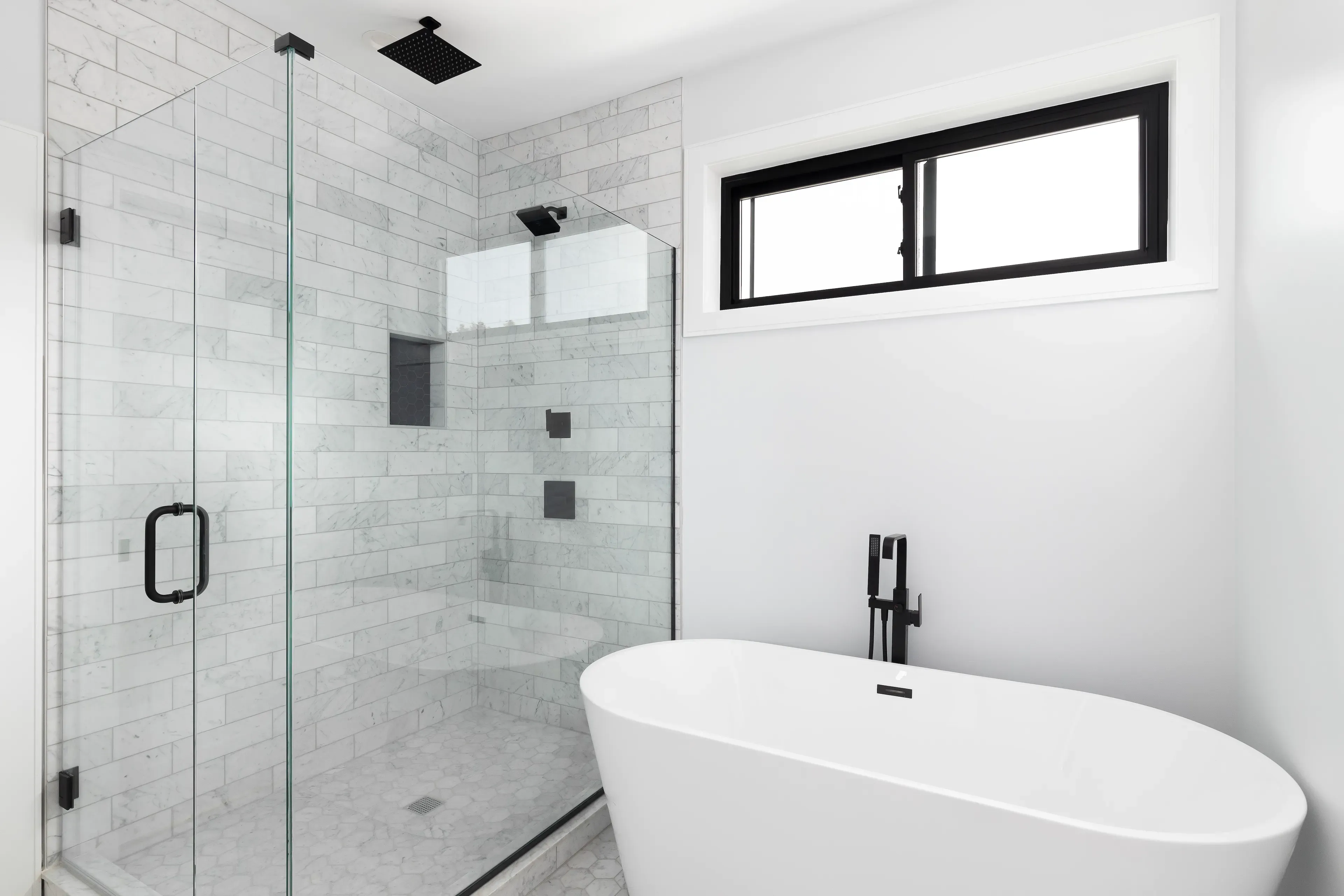 Modern bathroom featuring a sleek glass shower door, minimalist bathtub, and elegant decor, highlighting custom glass solutions.