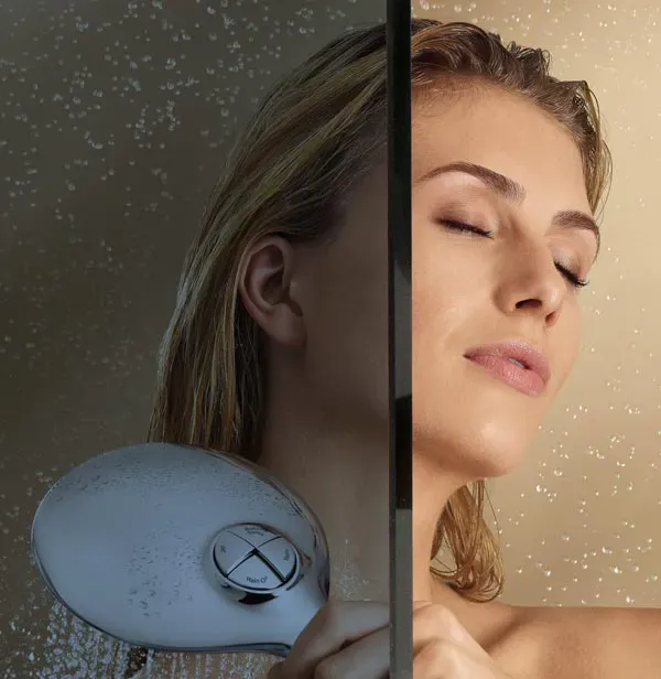 Woman enjoying a shower behind a sleek glass door, highlighting custom glass features ideal for shower doors and mirrors, emphasizing the quality of tempered glass in modern bathroom design.