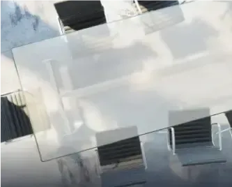 Custom glass table top with beveled edges, surrounded by outdoor chairs, showcasing tempered glass design.