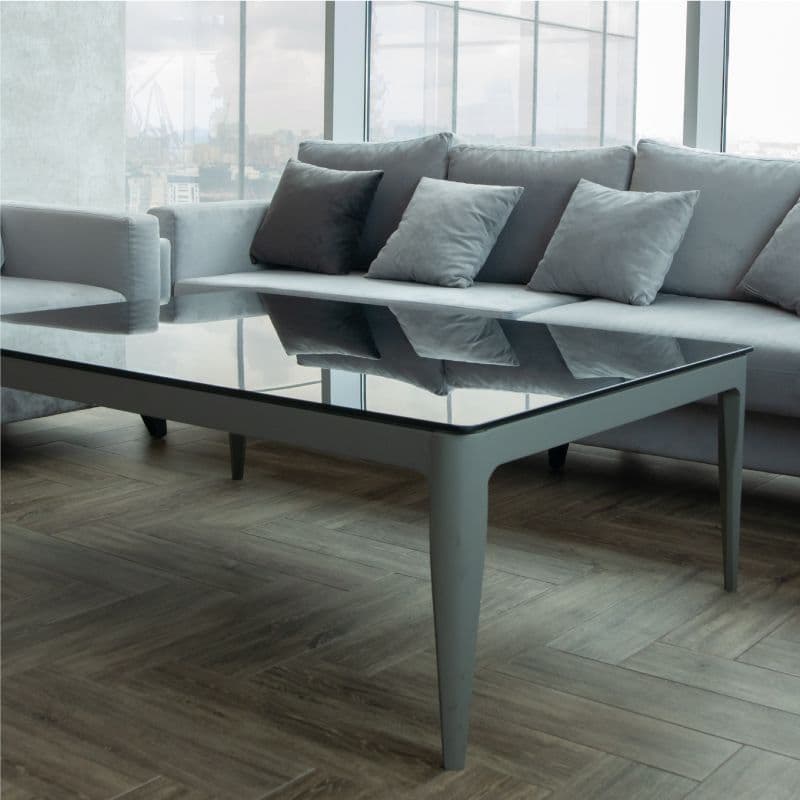 Modern living room featuring a sleek glass table top, surrounded by plush sofas, highlighting custom glass and contemporary design elements.