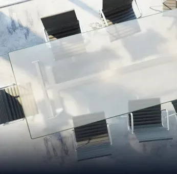 Custom glass table top with a tempered glass surface, surrounded by chairs, showcasing contemporary design and quality craftsmanship.