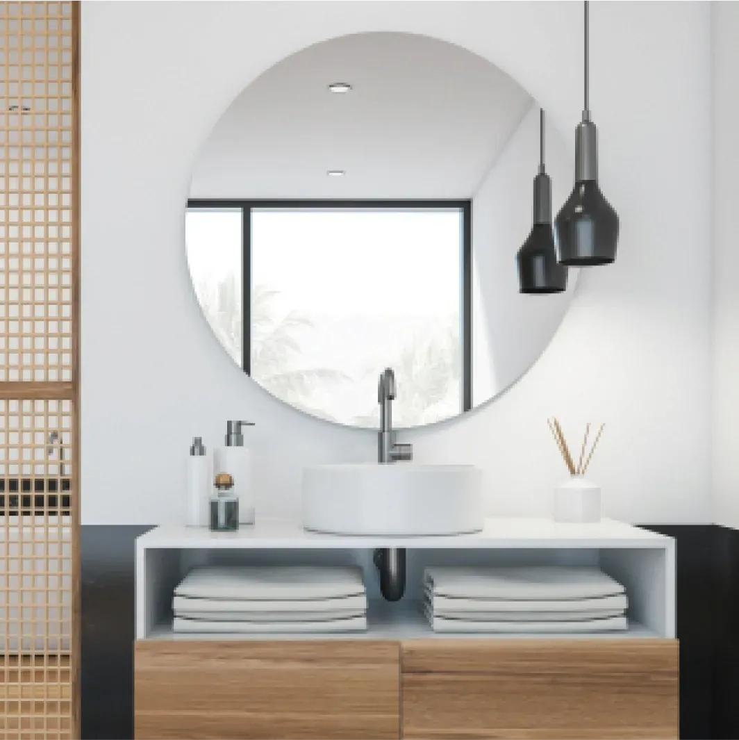 Modern bathroom featuring a round mirror, sleek sink, and stylish storage. Ideal for showcasing custom glass design, including mirrors and tempered glass elements.