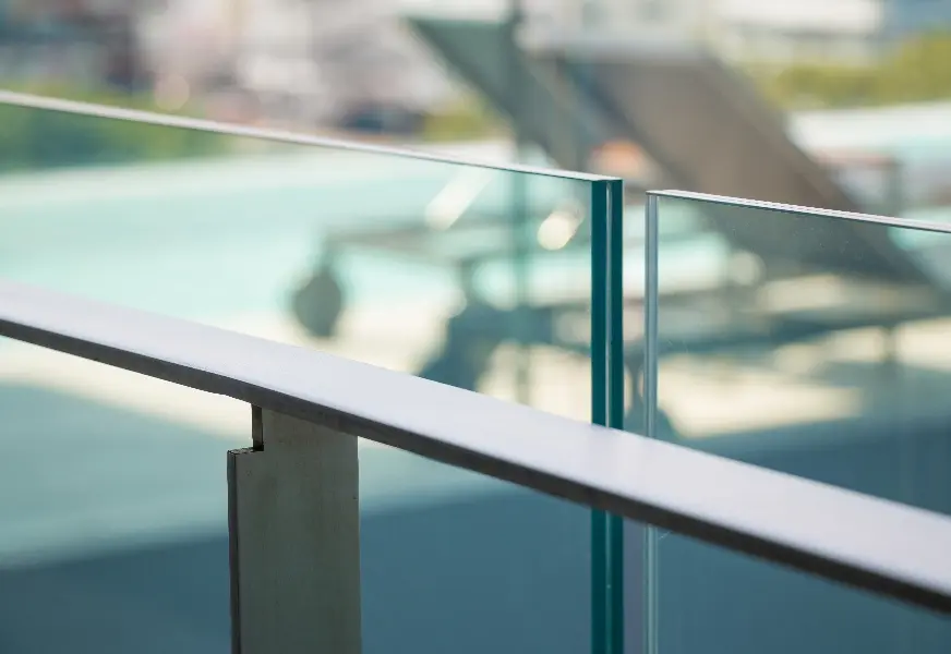 Custom glass railing showcasing clear tempered glass panels, ideal for modern shower doors or table tops, featuring a sleek beveled glass edge.