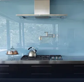 Kitchen featuring a sleek glass backsplash, custom glass design, modern kitchen appliances, and stylish accents, showcasing tempered glass suitability for contemporary interiors.