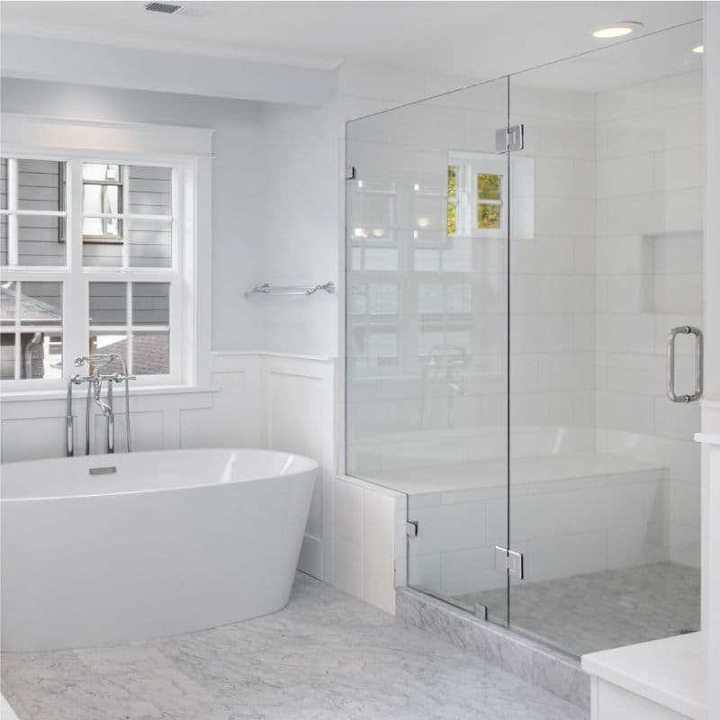 Modern bathroom featuring a clear glass shower door and elegant freestanding tub, complemented by stylish fixtures; ideal for showcasing custom glass solutions like tempered glass and beveled edges.