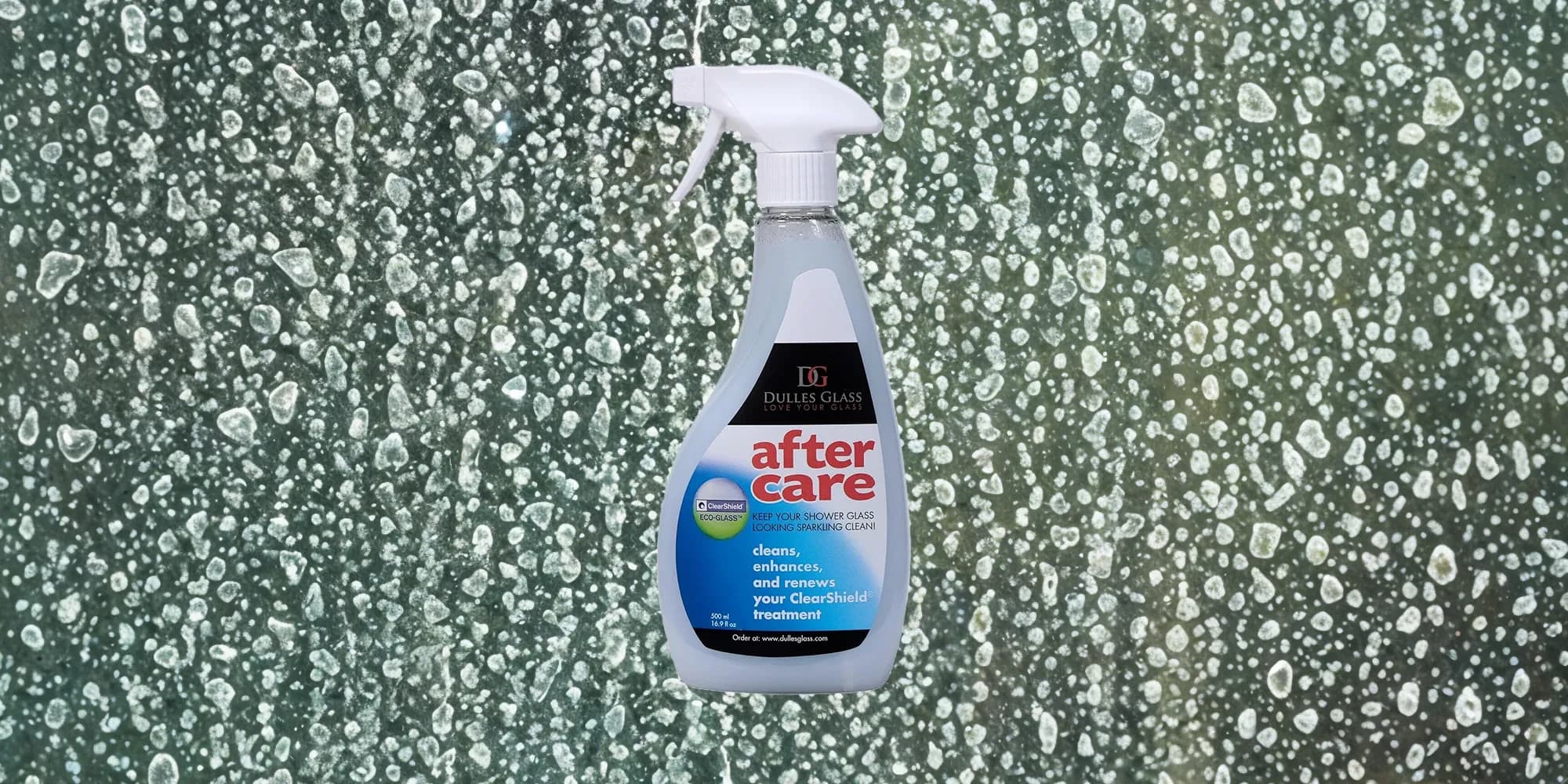 A bottle of Dulles Glass After Care spray cleaner is shown in front of a glass shower door covered in water droplets.