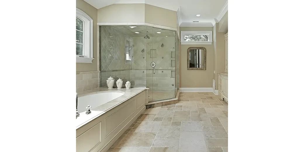 Custom glass shower doors in a modern bathroom featuring a sleek design, a textured glass finish, and an elegant mirror, complemented by a tiled floor and premium fixtures.