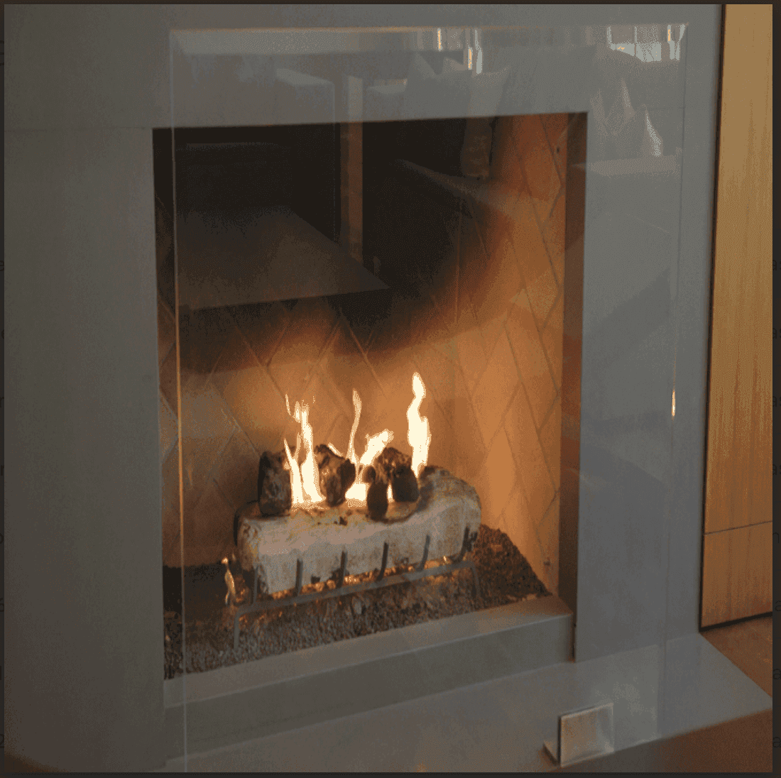 Custom glass fireplace design featuring tempered glass for a modern look, highlighting the flame and stone features. Ideal for upscale interiors, complements shower doors, table tops, and mirrors.