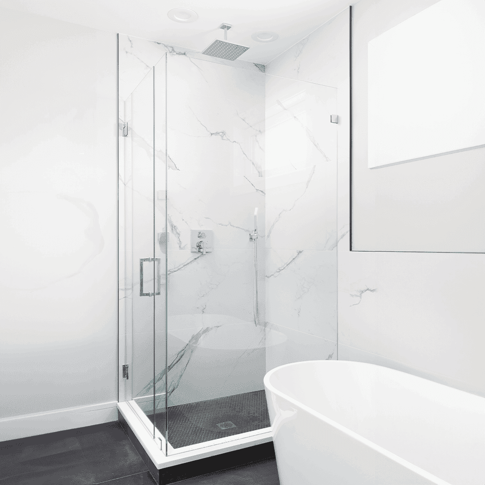 Modern bathroom featuring a sleek glass shower door and marble walls