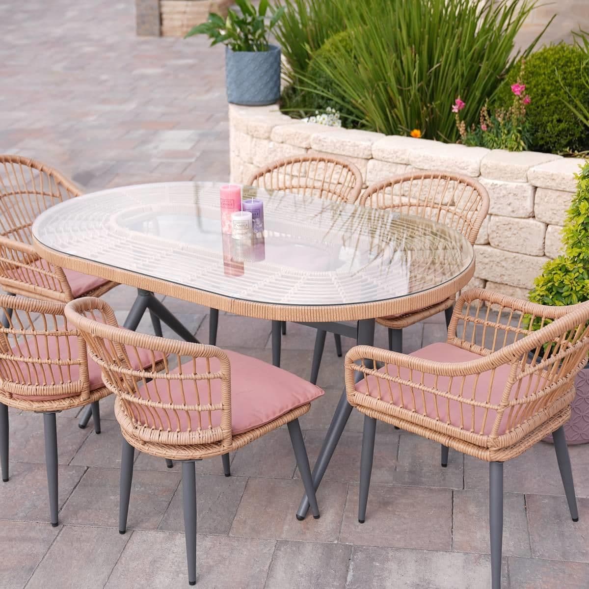 Outdoor dining set with glass-top table and wicker chairs on patio